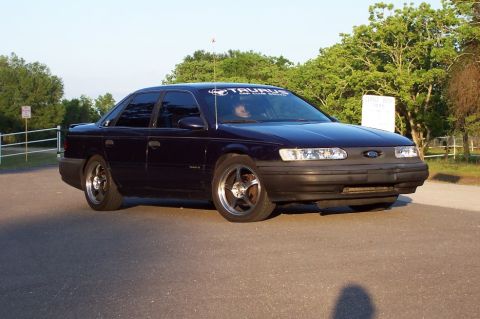 1993 Ford Taurus - A dark blue 1993 Ford Taurus sedan is parked outdoors, showing its front 3/4 profile.