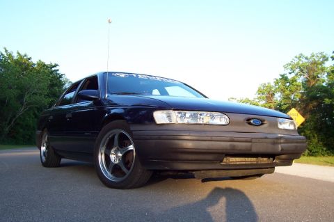 1993 Ford Taurus - This sedan, identified as a Taurus by its windshield banner, is seen from a 3/4 front angle.
