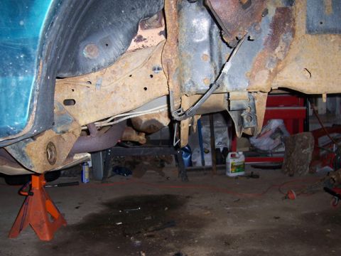 1996 Ford Bronco - Vehicle frame and suspension components showing significant rust, supported by jack stands.