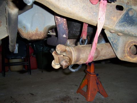 1996 Ford Bronco - Close-up view of a vehicle's undercarriage, focusing on the driveshaft and suspension components supported by jack stands.