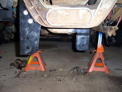 1996 Ford Bronco - Vehicle underbody components, including a lift kit, are visible while the vehicle is supported by jack stands.