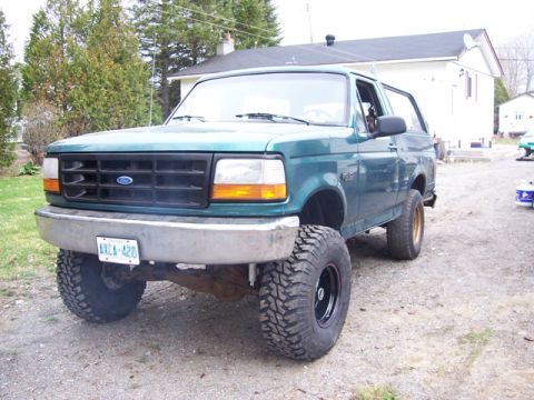 1996 Ford Bronco - This lifted 1996 Ford Bronco features a prominent grille and a custom wheel setup, suggesting off-road modifications.