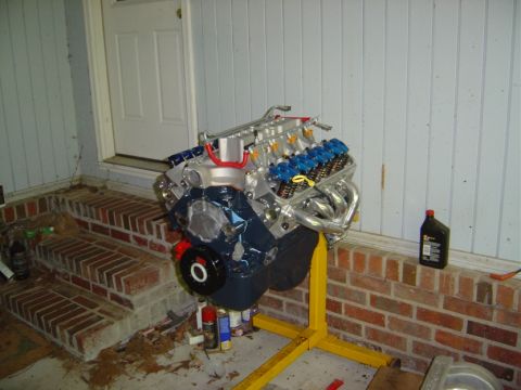 1986 Ford Bronco - V8 engine on a stand, likely for a swap project. Bottle of oil nearby.