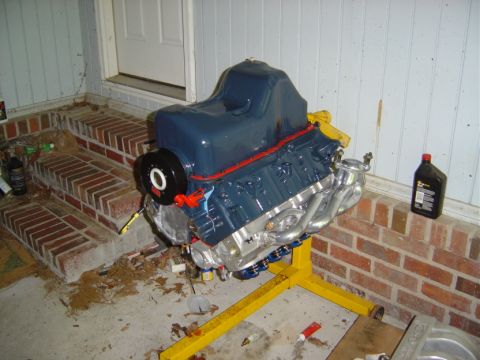 1986 Ford Bronco - A V8 engine is mounted on a yellow engine stand, ready for installation or work.