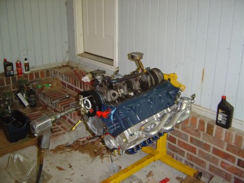 1986 Ford Bronco - A V8 engine is mounted on a yellow stand, ready for installation or work.