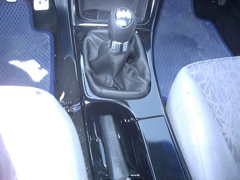 1995 Ford Probe - The interior of a car is visible, focusing on the center console with a manual transmission shifter and handbrake.