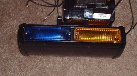 1997 Ford Crown Victoria - This is a police light bar assembly with blue and amber lenses and exposed wiring.