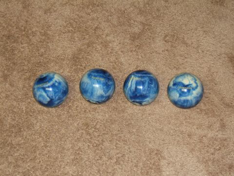 1998 Ford Taurus - Four bowling balls with a blue and white marbled pattern are laid out on a textured brown surface.