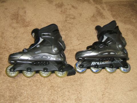 1998 Ford Taurus - Two pairs of Rollerblade brand inline skates are shown side-by-side on a carpeted surface.