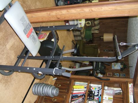 1998 Ford Taurus - A weight bench is shown in a room with a bookshelf filled with books.