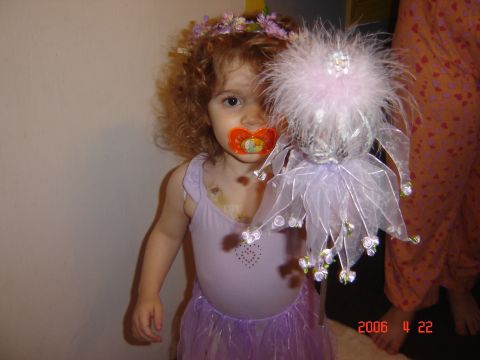 1993 Ford Bronco - A young child dressed as a fairy, complete with a flower crown and wand, holds a pacifier.