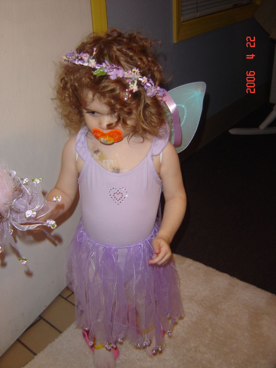 Child in fairy costume with pacifier and flower crown