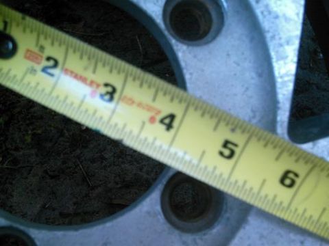 1986 Ford Bronco - Measuring a wheel rim with a tape measure. The rim appears to be silver metal.