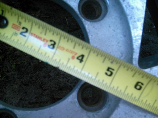 Stanley tape measure across a silver wheel rim, showing inches 2 through 6