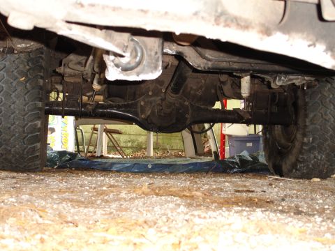 1989 Ford Bronco - Undercarriage view of a vehicle's rear axle and suspension components.