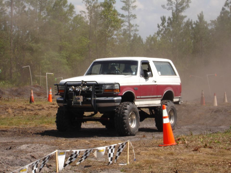 White and maroon lifted SUV with off-road tires and brush guard