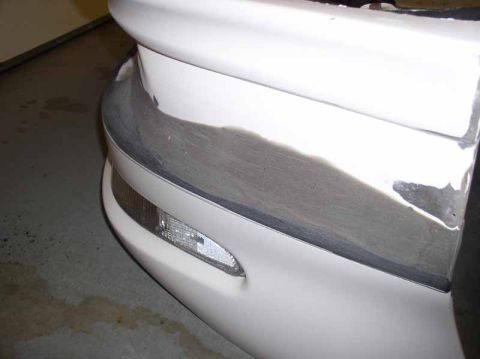 1996 Ford Probe - Car bumper repair in progress, with visible body filler and primer on the surface.