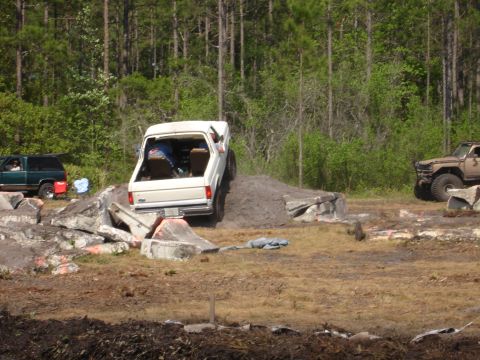 1989 Ford Bronco - A white Ford Bronco navigates an off-road obstacle course with other vehicles present.