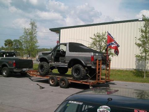 1986 Ford Bronco - Modified Ford Bronco being towed, with a Confederate flag displayed.