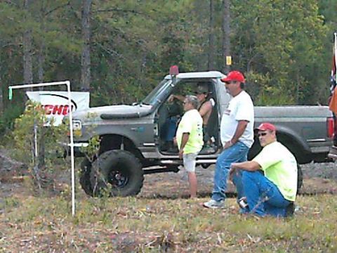 1986 Ford Bronco - A modified Ford F-Series truck with people gathered around it in an outdoor setting.