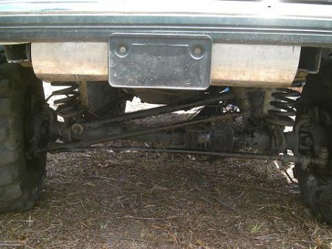 1986 Ford Bronco - Close-up of the rear suspension and axle assembly of an off-road vehicle.