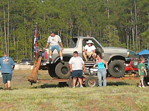 1986 Ford Bronco - A lifted 1987 Ford Bronco is parked on a trailer with several people gathered around.