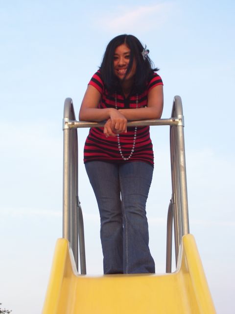 1994 Ford Probe - A woman smiles while posing on a playground slide against a clear sky.