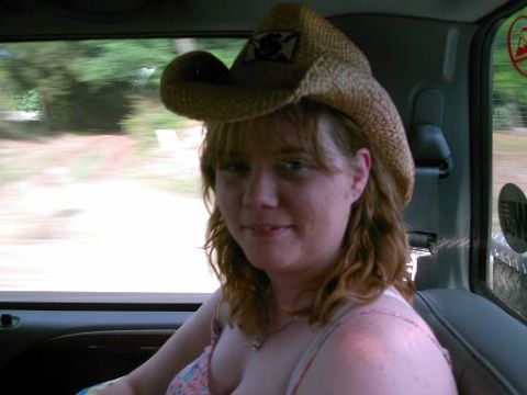 1986 Ford Bronco - A woman wearing a cowboy hat looks out the window from the passenger seat of a vehicle.