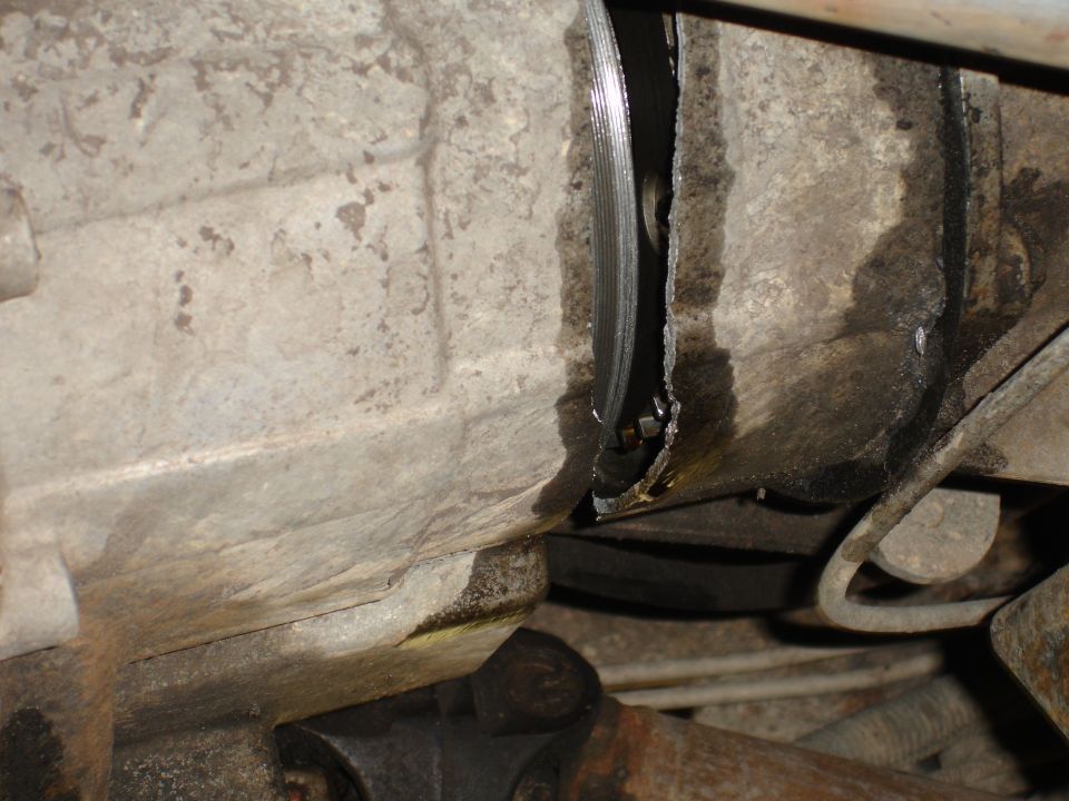 Close-up of a cracked transmission housing with visible damage and fluid leakage