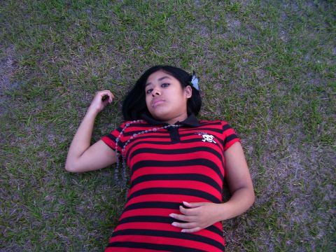 1994 Ford Probe - A young woman is lying on the grass, looking up at the camera.