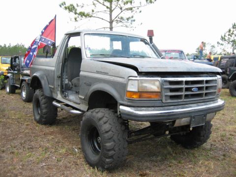 1989 Ford Bronco - Modified Ford Bronco with lifted suspension and off-road tires is parked outdoors.