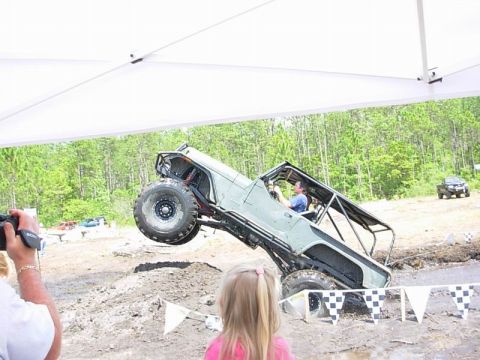 1989 Ford Bronco - An off-road vehicle is captured mid-air during an event, with another vehicle visible in the background.