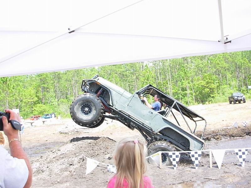Off-road vehicle mid-air over mud pit
