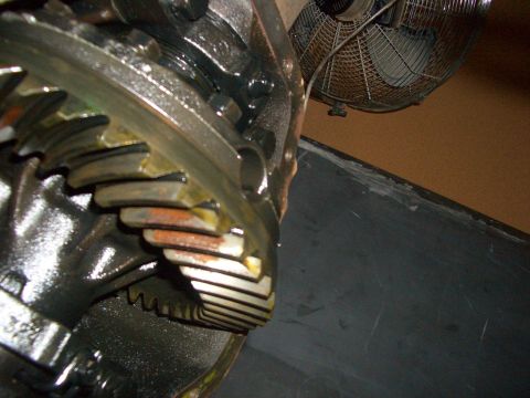 1990 Ford Bronco - Differential gears showing wear and yellow grease, with a fan in the background.