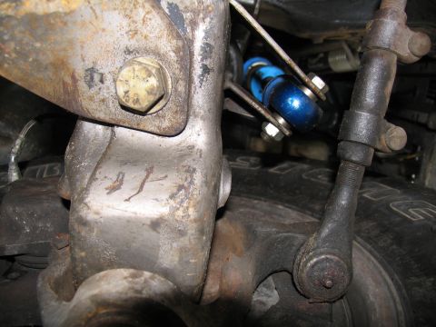 1984 Ford Bronco - Detail shot of vehicle suspension system, a blue shock absorber and various metal linkages.