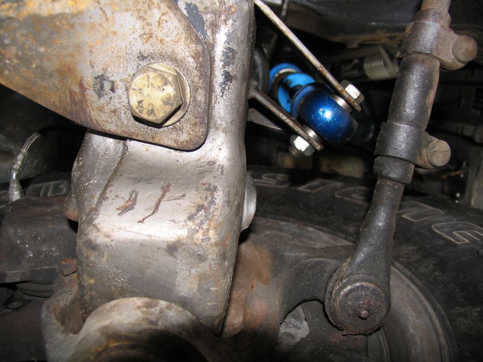 Close-up of suspension components with blue shock absorber and tire tread