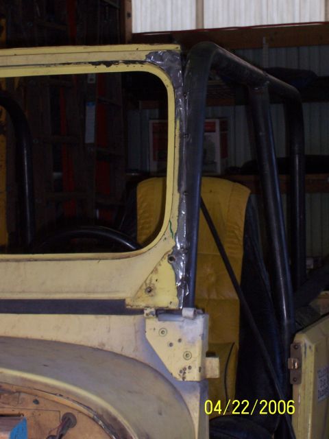 1982 Ford Customline - Close-up of a yellow Jeep CJ door frame and roll cage, showing modifications and a date stamp.