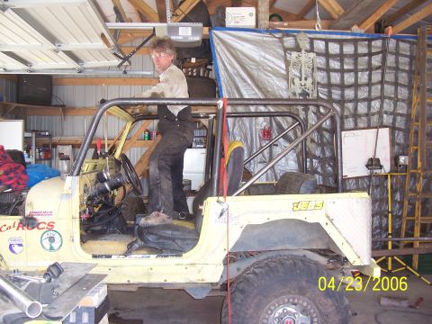 1982 Ford Customline - A yellow Jeep with a custom roll cage and diamond plate fender is seen in a garage.