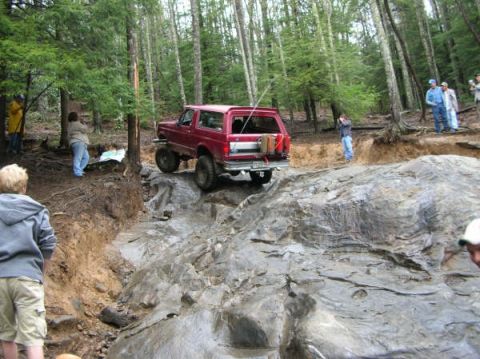 1995 Ford Bronco - A red 1995 Ford Bronco navigates a challenging rocky off-road course.