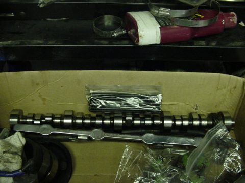 1995 Ford Mustang - A camshaft and other engine components are laid out in a cardboard box, ready for installation.