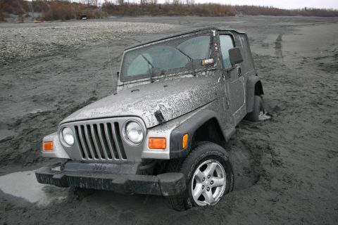 2003 Jeep TJ - Jeep TJ stuck in mud, likely off-roading in a remote area.