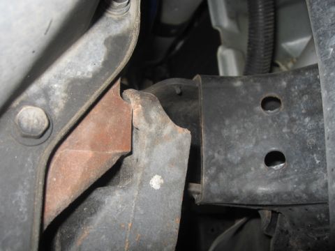 2000 Jeep TJ - Close-up view of a vehicle's engine mount bracket, showing signs of wear and rust.