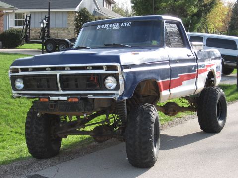 1977 Ford F-150 - A lifted 1977 Ford F-150 pickup truck with a blue, white, and red paint scheme is shown from the front.