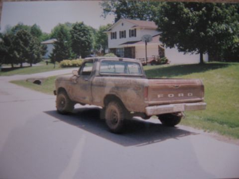 1977 Ford F-150 - A dusty 1977 Ford F-150 pickup truck is seen from the rear in front of a house.