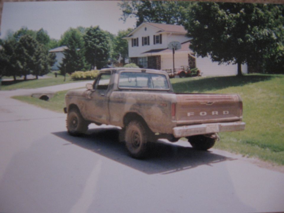 Brown 1977 Ford F-150 pickup truck, rear 3/4 view, dusty condition, parked on asphalt