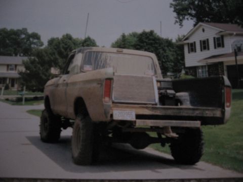 1977 Ford F-150 - A lifted 1977 Ford F-150 pickup truck is parked on a residential street, viewed from the rear.