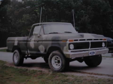 1977 Ford F-150 - This 1977 Ford F-150 pickup truck features a camouflage paint scheme and a prominent Ford grille.