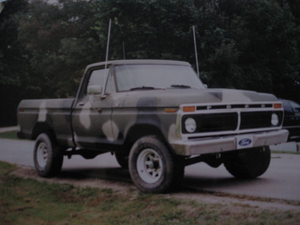 Camouflaged 1977 Ford F-150 pickup truck, front 3/4 view