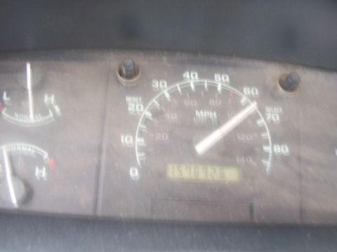 1994 Ford F-150 - Close-up of a dusty 1990s Ford truck instrument cluster showing the 0-85 MPH speedometer with dual MPH/km/h scales, RESET and SELECT button…
