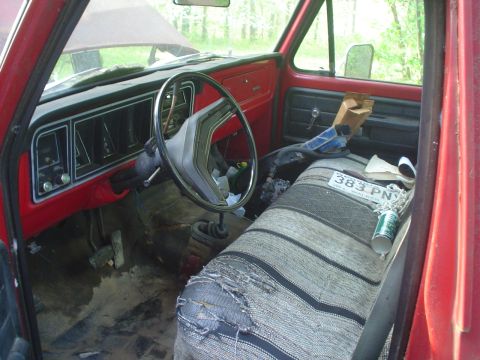1976 Ford F-100 - The interior of this pickup truck shows a worn bench seat and a dashboard with visible gauges.